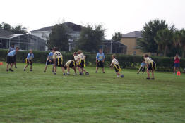 Alex is #5, playing quarterback, about to hand off the ball to Justin, who is #6.