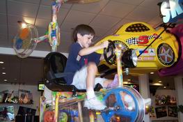 Patch pedaling himself to the roof on a game/ride at Chuck E Cheese's