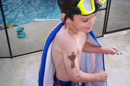 Making a muscle to show off his temporary tattoo