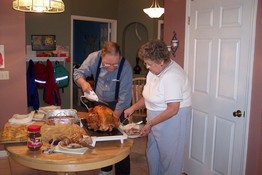 Dad and Aunt Lois carving the beast