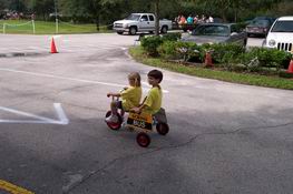 Catching a ride in the Trike-A-Thon with his classmate