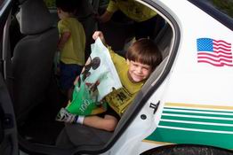 He's looking a little too comfortable in the back of that police car!